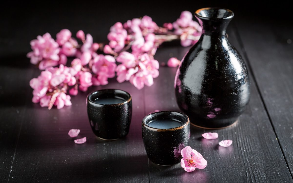 Unfiltered white sake sake on black table